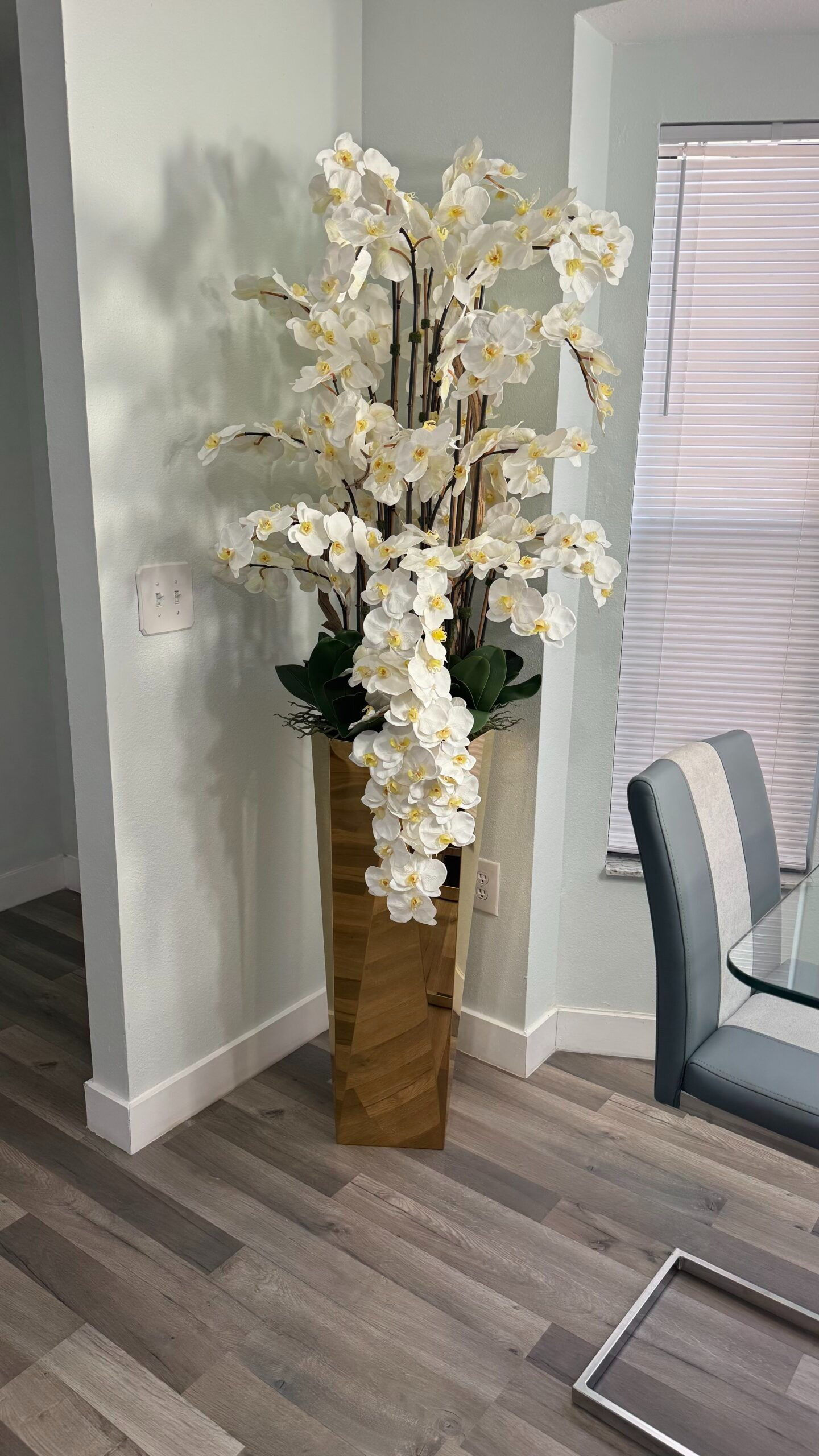 Kaskadierende weiße Orchideen in einer goldgeschliffenen Vase