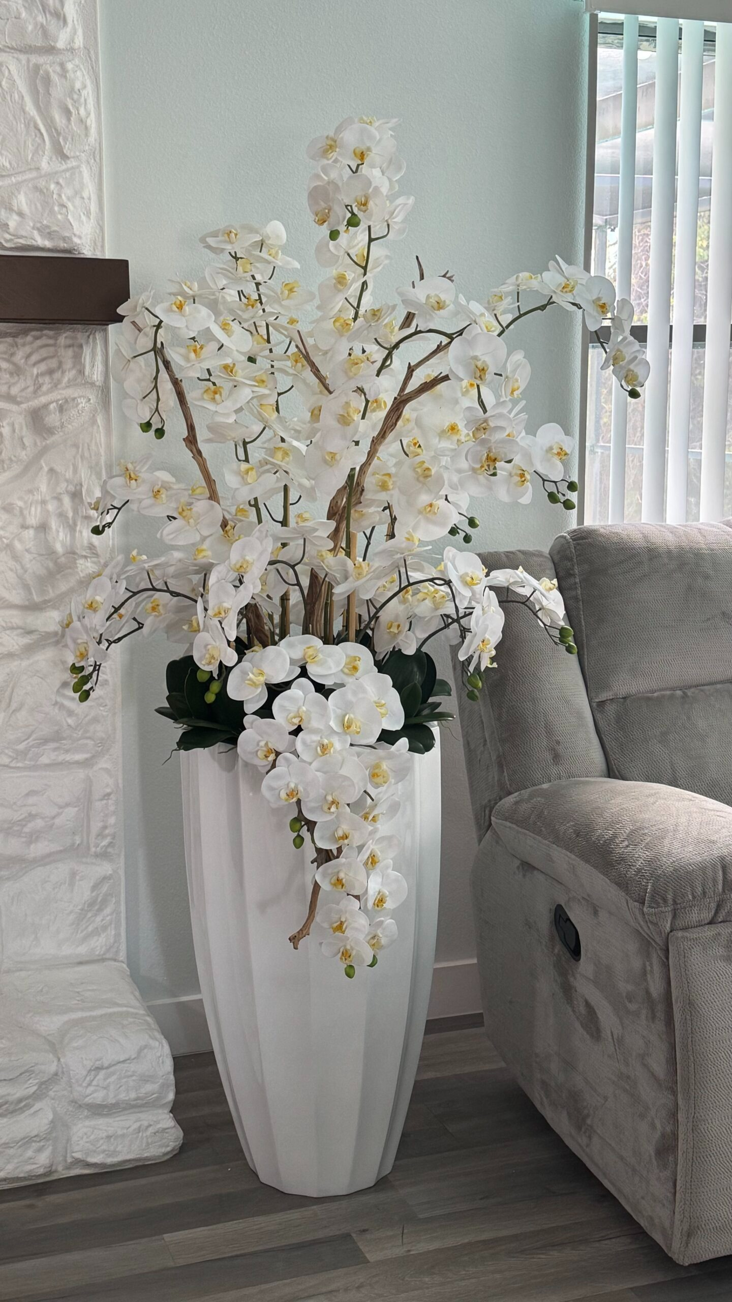 Kaskadierende weiße Orchideen in einer weißen Vase