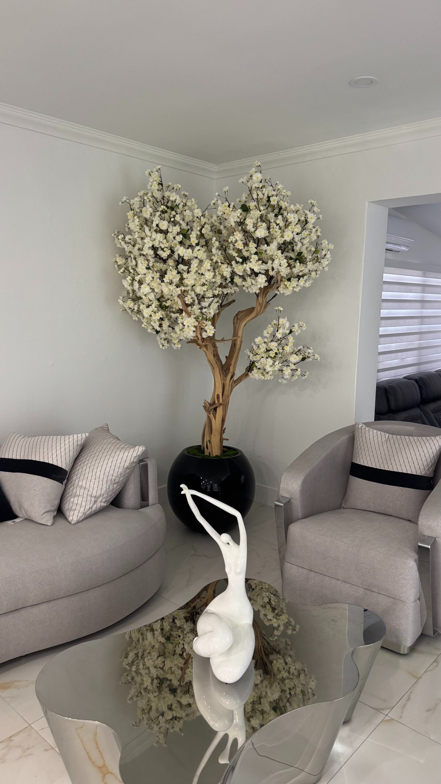 Weißer Kirschblütenbaum in einer schwarzen runden Vase