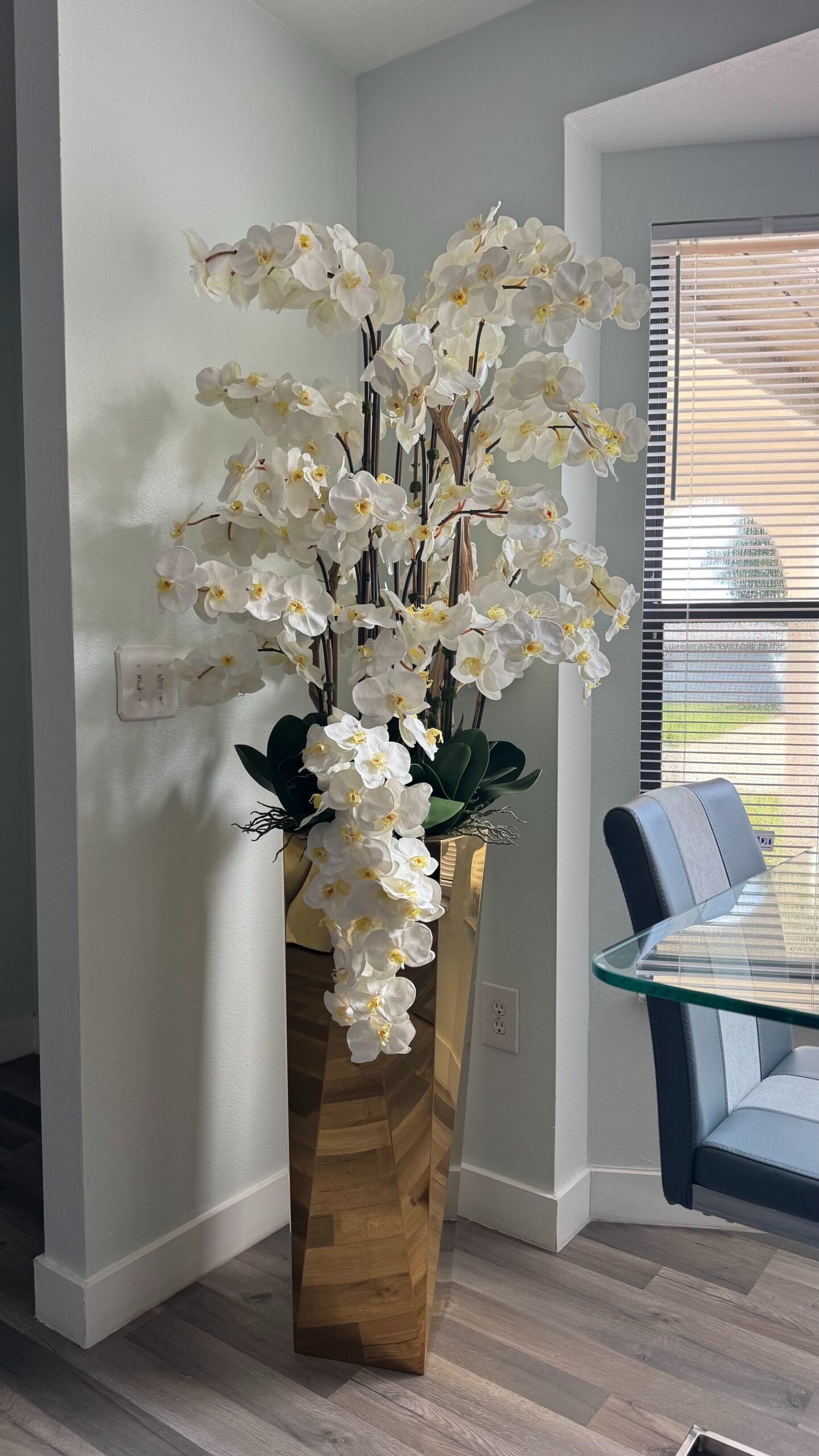 Kaskadierende weiße Orchideen in einer goldgeschliffenen Vase